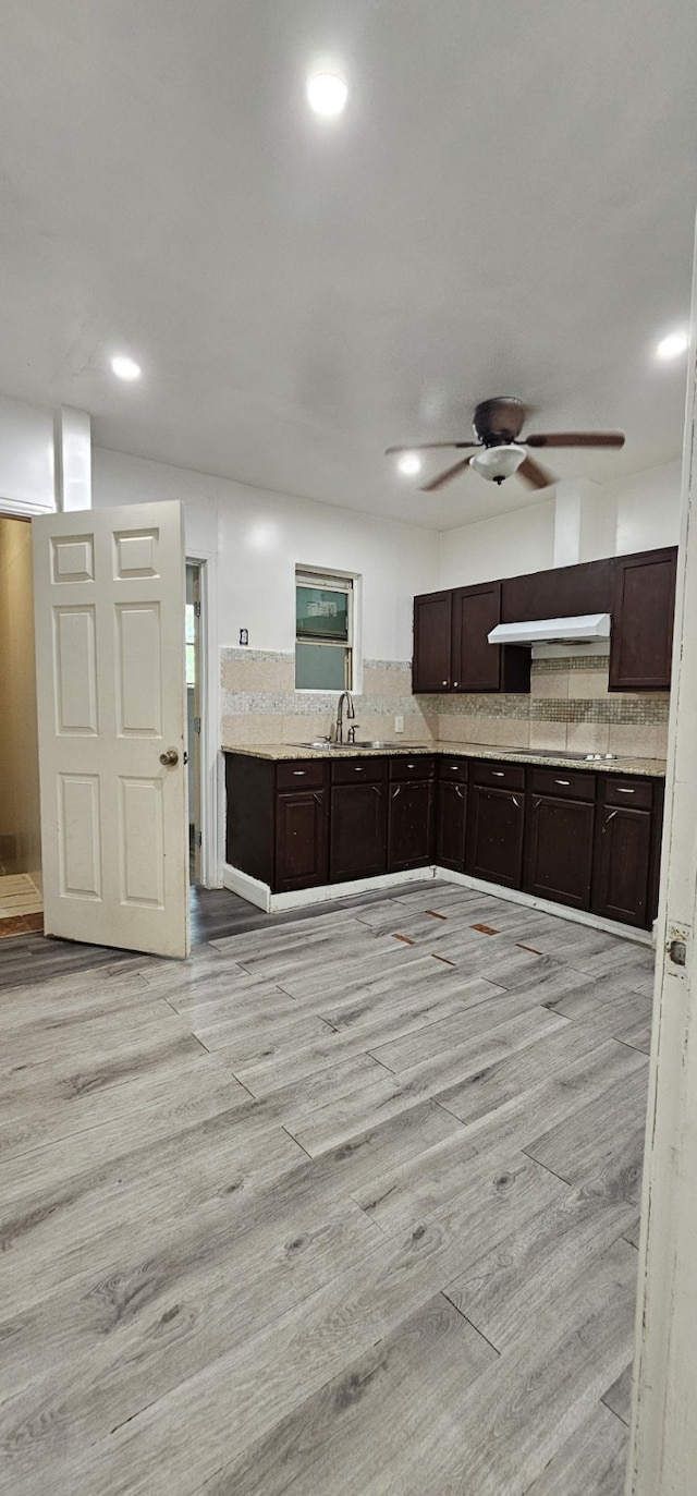 kitchen with ceiling fan, light wood-type flooring, sink, and decorative backsplash