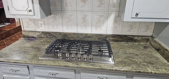 kitchen with decorative backsplash, white cabinetry, and stainless steel gas cooktop