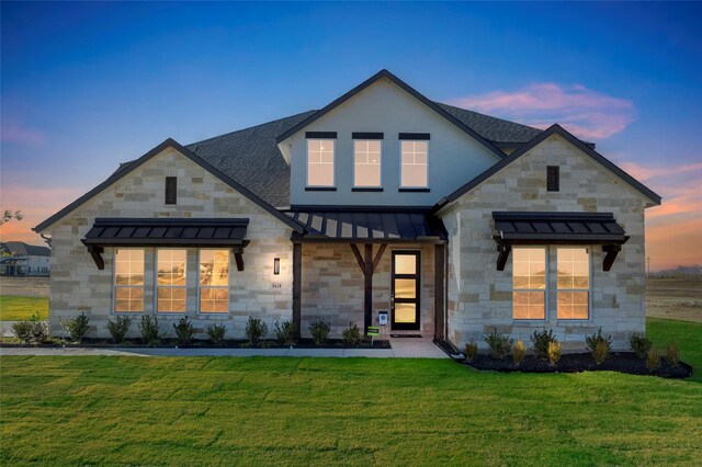5610 Gaelic Dr, Celina, TX 75009 - view of front of home with a standing seam roof, a front yard, roof with shingles, and stone siding