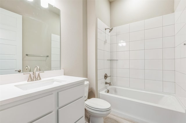 full bathroom with vanity, tiled shower / bath, and toilet