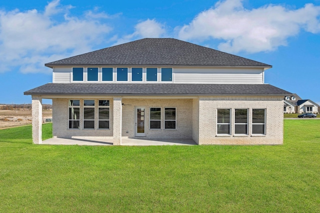 rear view of house featuring a lawn and a patio