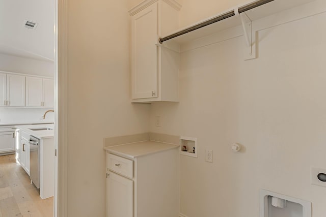 laundry room with sink, gas dryer hookup, cabinets, electric dryer hookup, and light hardwood / wood-style floors