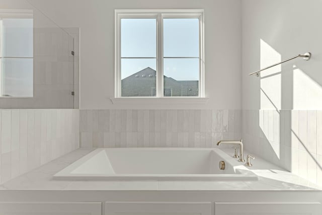 bathroom featuring tiled tub