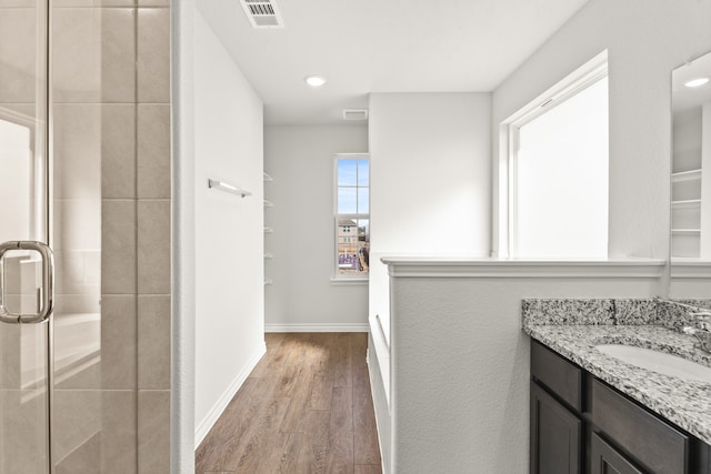 bathroom with vanity, a shower with shower door, and wood-type flooring