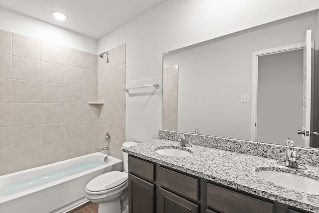 full bathroom with vanity, toilet, and tiled shower / bath combo