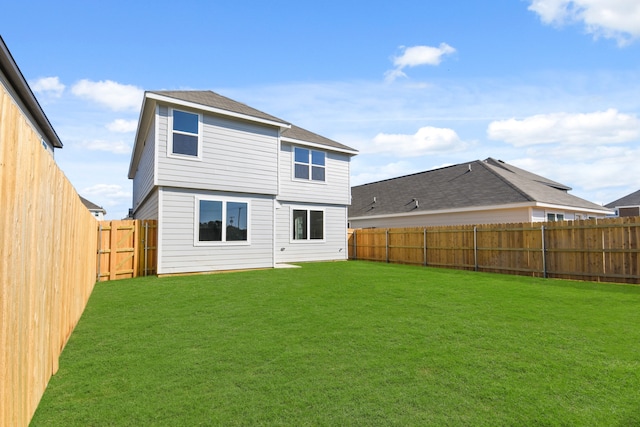 rear view of property featuring a lawn