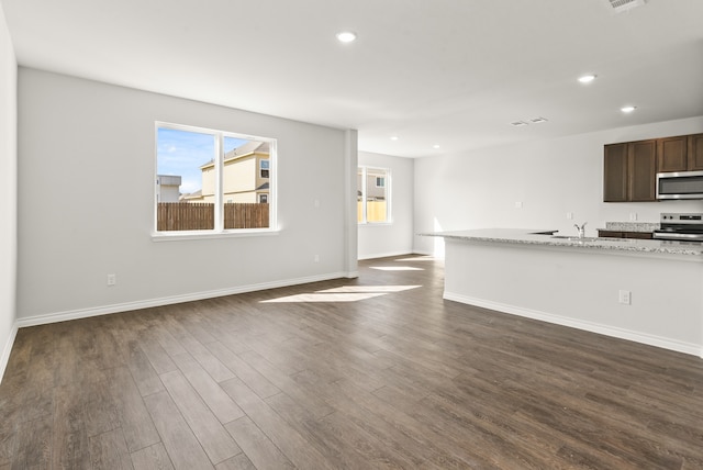 unfurnished living room featuring dark hardwood / wood-style floors and sink