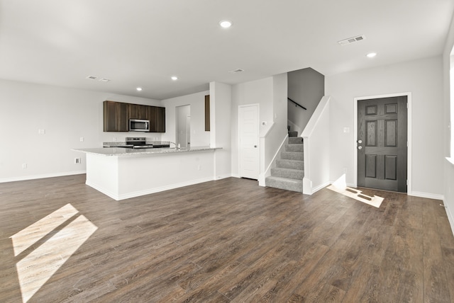 kitchen featuring dark brown cabinetry, stainless steel appliances, and dark hardwood / wood-style flooring