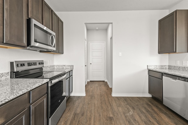 kitchen featuring dark wood-type flooring, stainless steel appliances, light stone countertops, and dark brown cabinetry