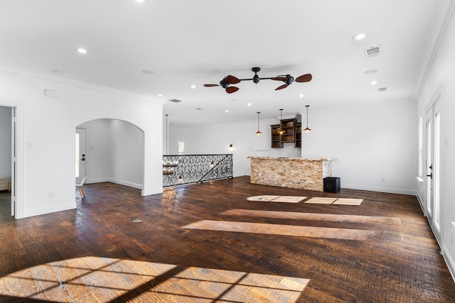 unfurnished living room featuring crown molding, dark hardwood / wood-style floors, and ceiling fan