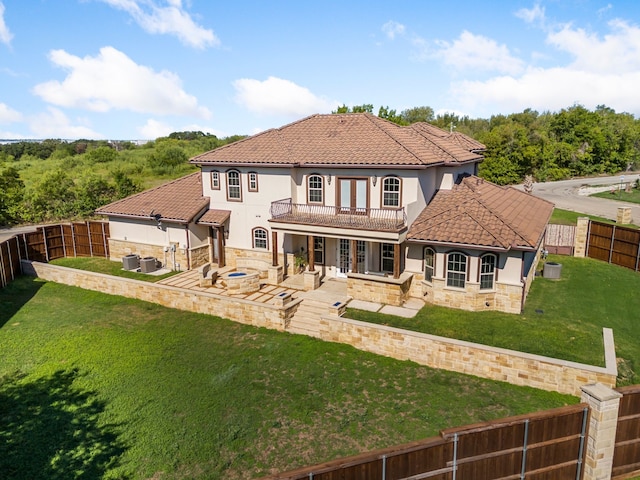 rear view of house with french doors, a balcony, a yard, cooling unit, and a patio