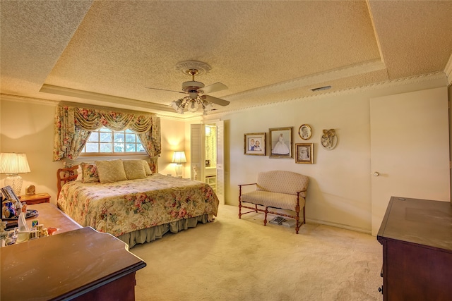 bedroom with ceiling fan, carpet floors, and a tray ceiling