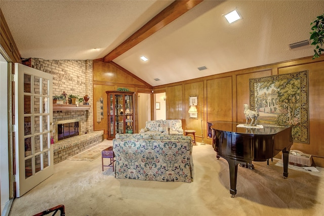 living area with vaulted ceiling with beams, wood walls, a brick fireplace, a textured ceiling, and light colored carpet