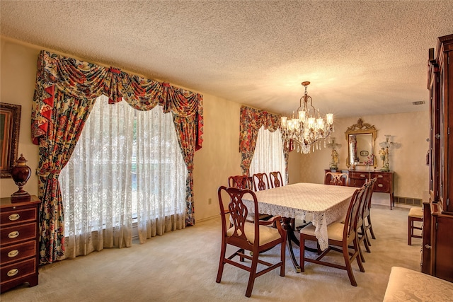 carpeted dining room featuring a textured ceiling and a chandelier