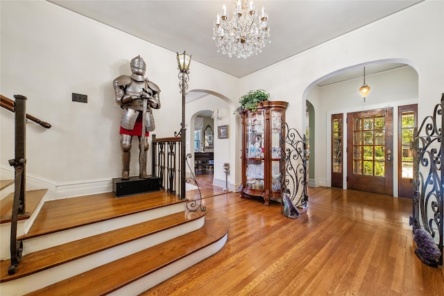 foyer entrance with wood-type flooring and a chandelier