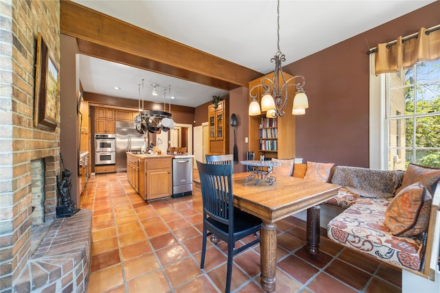 tiled dining space with a fireplace and an inviting chandelier