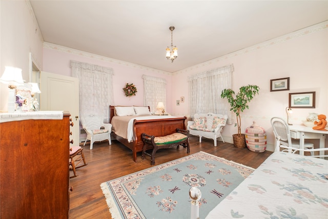 bedroom featuring an inviting chandelier, dark hardwood / wood-style floors, and crown molding