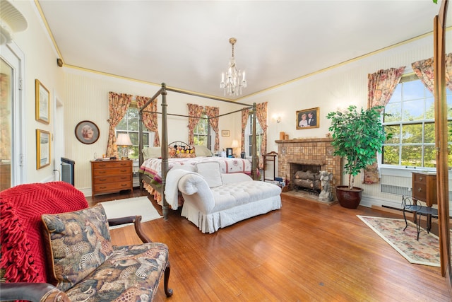 bedroom with a brick fireplace, crown molding, hardwood / wood-style floors, and multiple windows