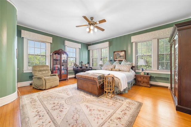 bedroom with ceiling fan, light hardwood / wood-style flooring, and multiple windows