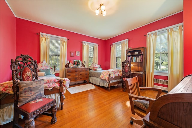 bedroom with wood-type flooring and multiple windows