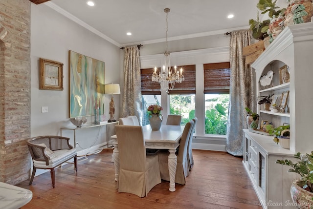 dining area featuring an inviting chandelier, ornamental molding, and dark hardwood / wood-style flooring