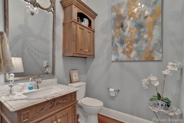 bathroom with vanity, toilet, and hardwood / wood-style flooring