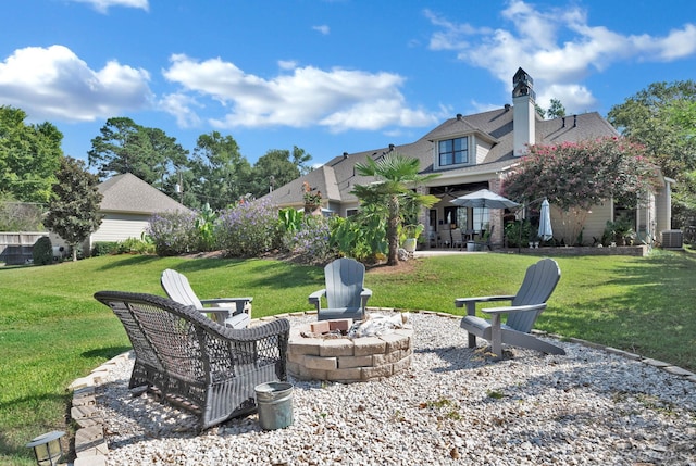 view of yard featuring a patio, central air condition unit, and a fire pit