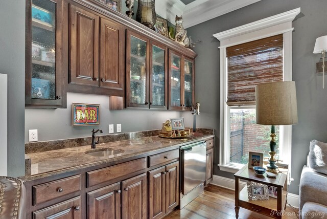 kitchen with dark brown cabinets, light hardwood / wood-style flooring, crown molding, and sink