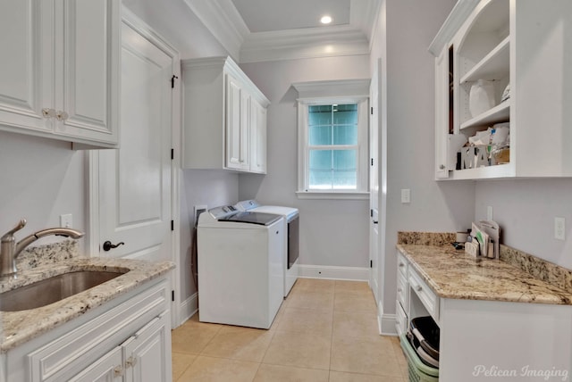 laundry room featuring cabinets, sink, light tile patterned floors, ornamental molding, and washer and clothes dryer