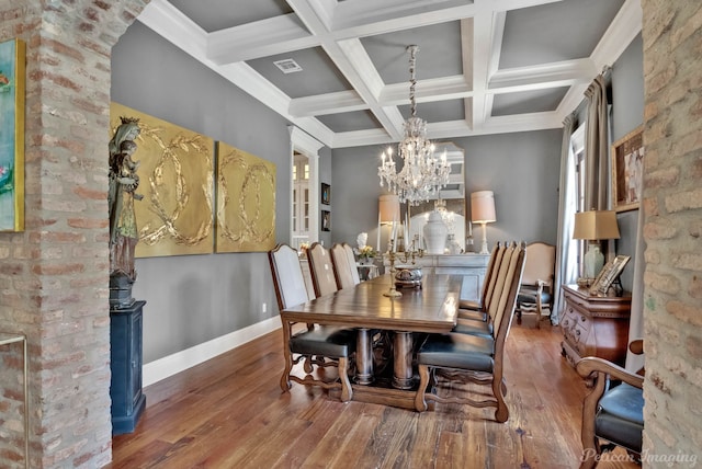 unfurnished dining area with a notable chandelier, wood-type flooring, beamed ceiling, and coffered ceiling