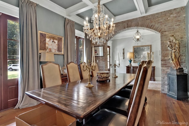 dining space with wood-type flooring, coffered ceiling, an inviting chandelier, and beamed ceiling