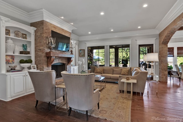 living room featuring ornamental molding, a fireplace, and dark hardwood / wood-style flooring