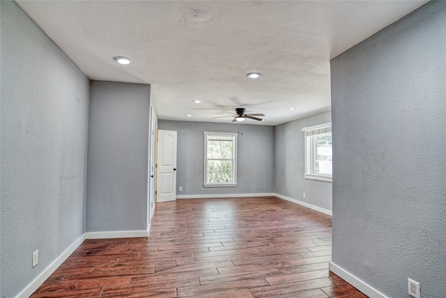 spare room with ceiling fan, a textured ceiling, and dark wood-type flooring