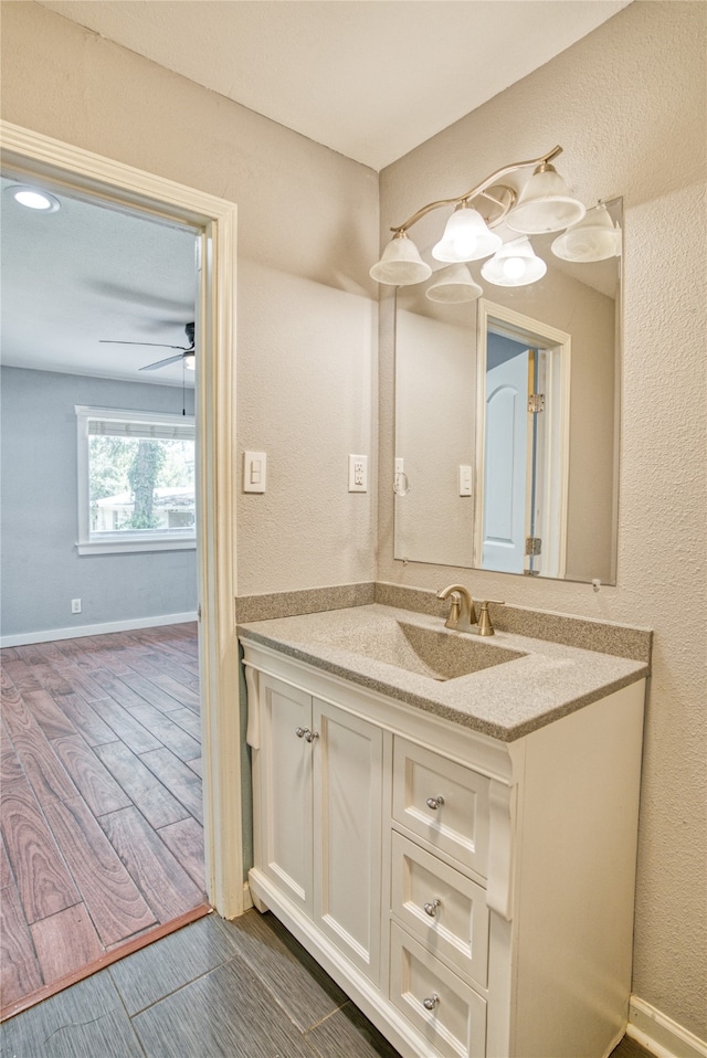 bathroom with wood-type flooring, vanity, and ceiling fan