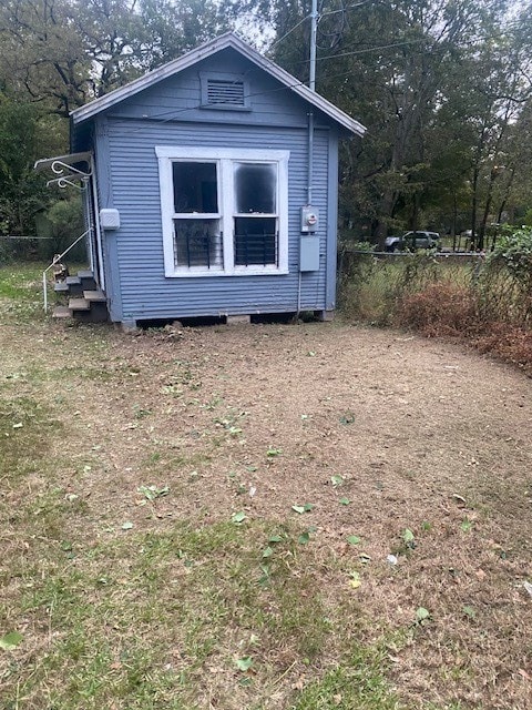 view of front of property with a porch, a front yard, and a shed