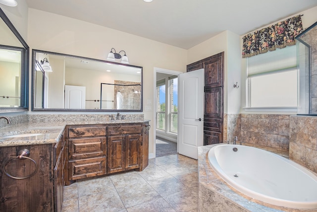 bathroom featuring vanity, tiled bath, and tile patterned floors