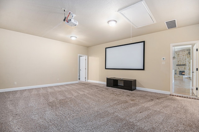 home theater room featuring a textured ceiling, a fireplace, and carpet