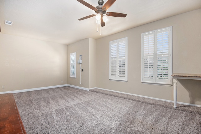 carpeted spare room with ceiling fan and plenty of natural light