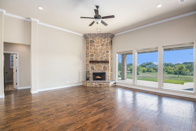 unfurnished living room with ceiling fan, dark hardwood / wood-style floors, and a stone fireplace