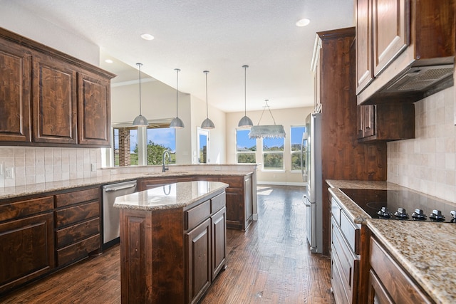 kitchen with hanging light fixtures, dark wood-type flooring, decorative backsplash, and a kitchen island