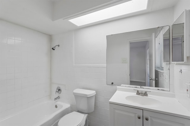 full bathroom featuring tile walls, vanity, toilet, and tiled shower / bath combo