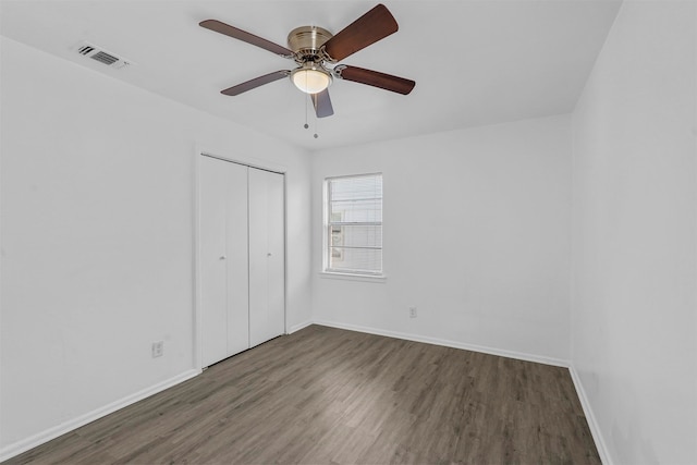 spare room with ceiling fan and dark wood-type flooring