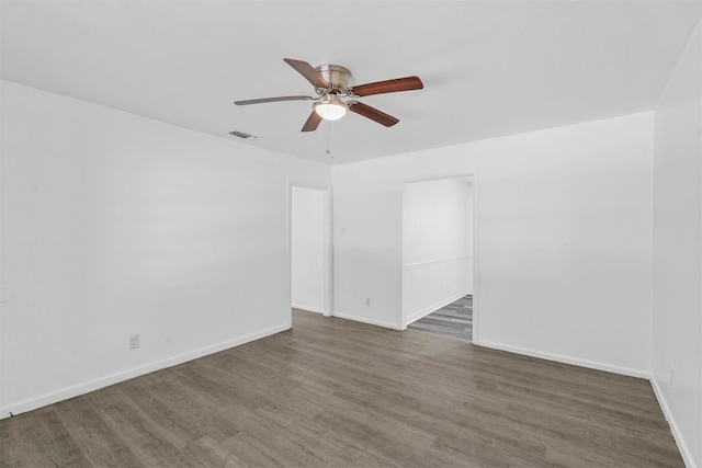 empty room with ceiling fan and dark wood-type flooring