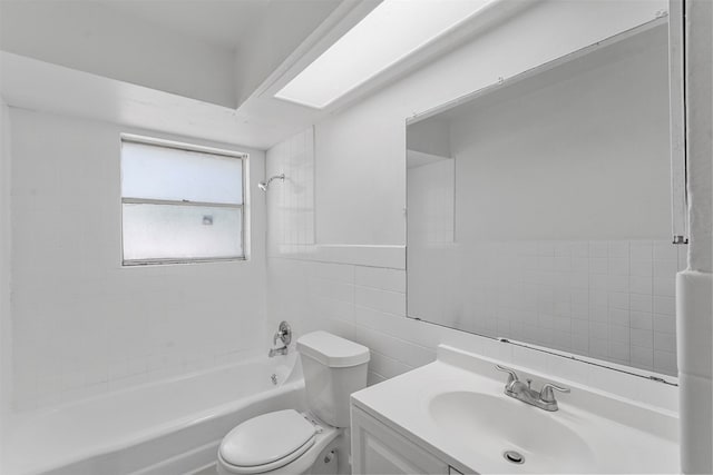 full bathroom with tile walls, vanity, toilet, and tiled shower / bath