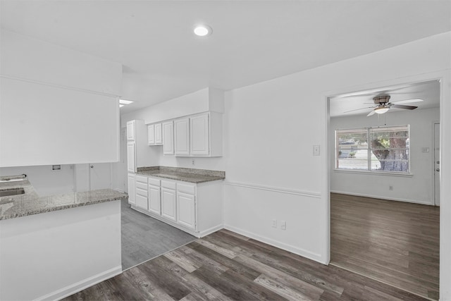 kitchen featuring ceiling fan, white cabinets, light stone countertops, and dark wood-type flooring