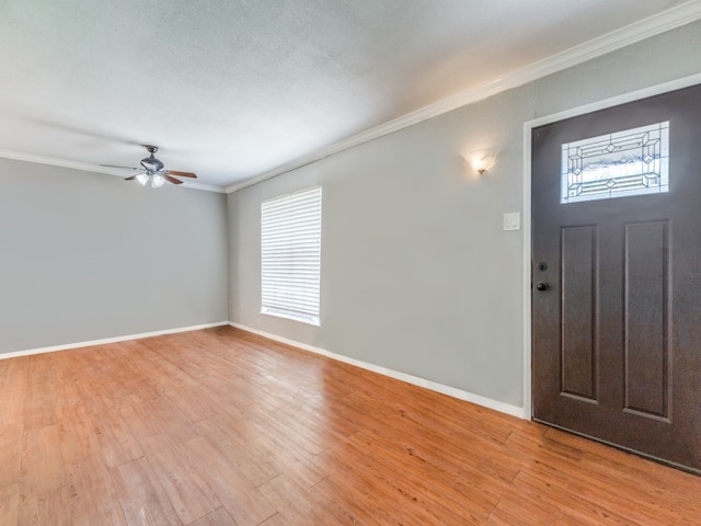 entryway featuring ceiling fan, a textured ceiling, light wood-type flooring, and ornamental molding