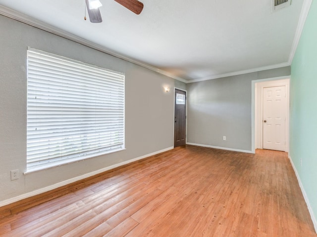 empty room with light hardwood / wood-style floors, ceiling fan, a healthy amount of sunlight, and crown molding