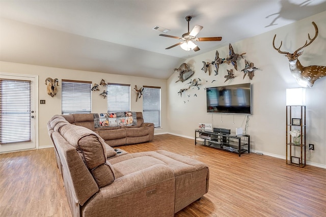 living room featuring ceiling fan, vaulted ceiling, and wood-type flooring