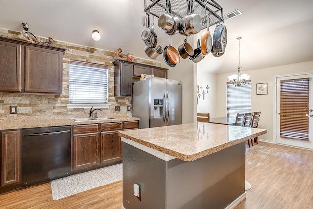 kitchen with light hardwood / wood-style floors, a chandelier, black dishwasher, sink, and stainless steel fridge with ice dispenser