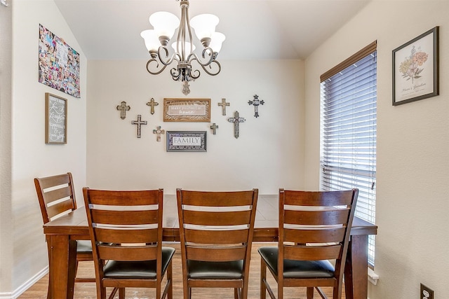 dining room featuring vaulted ceiling, a chandelier, and hardwood / wood-style floors